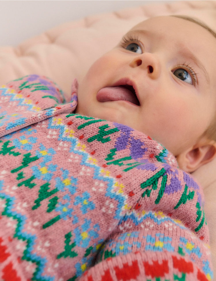 Baby lying down wearing Boden fair isle knit