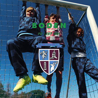 Drei Kinder spielen hinter einem Fußballtor mit dem „Boden“-Logo.