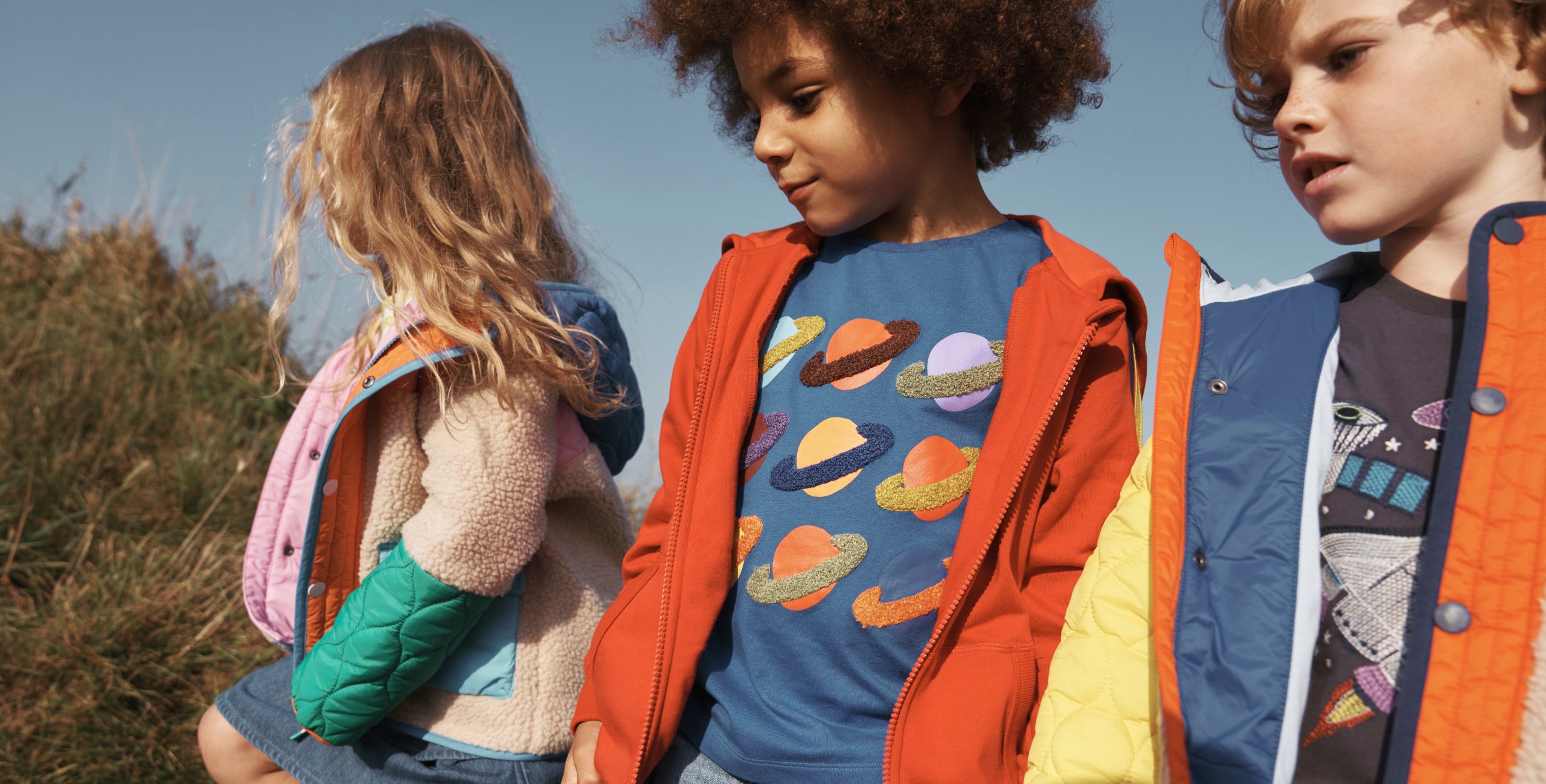 Boy wearing colourful Boden superstitch t-shirt with planets