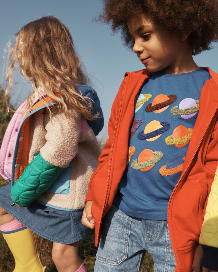 Boy wearing colourful Boden superstitch t-shirt with planets