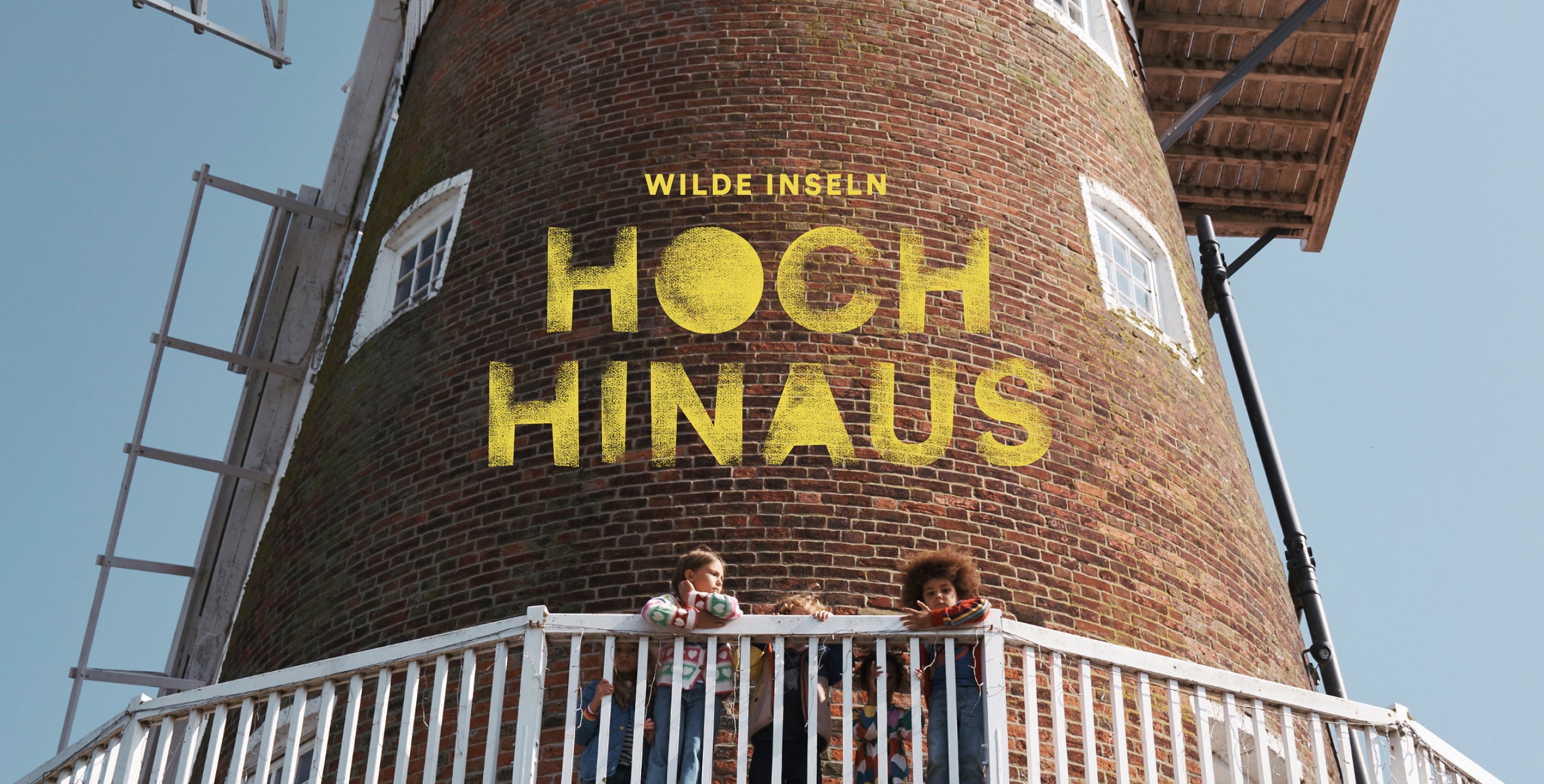 Wilde Iseln: Hoch Hinaus. Four children stood around a windmill wearing Boden clothes