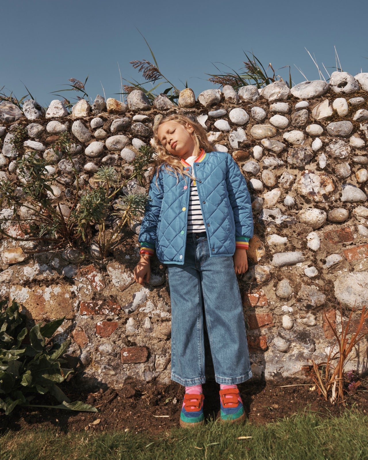 Girl leaning on a wall, wearing Boden jacket