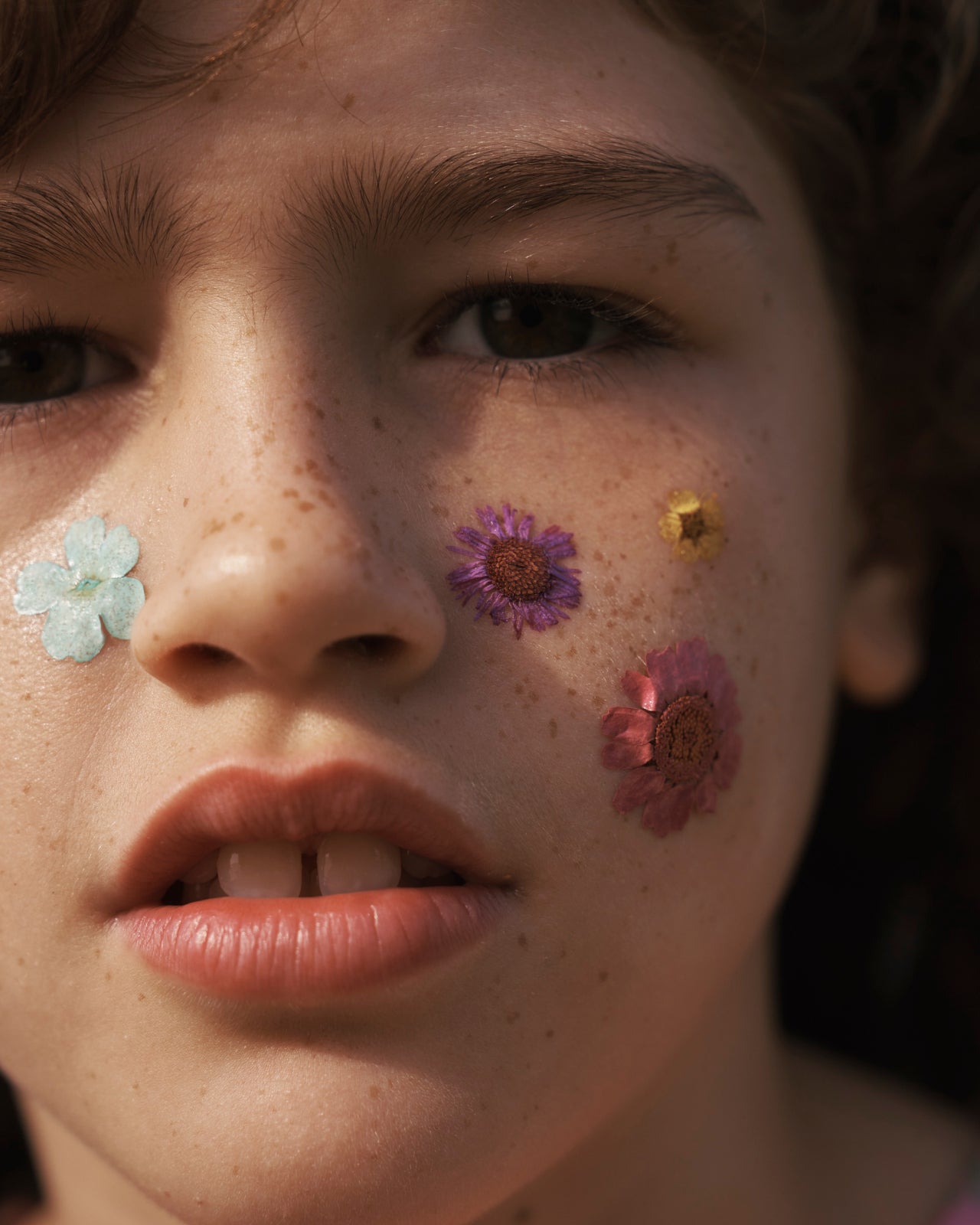 Close up of a girl with wildflowers on her face