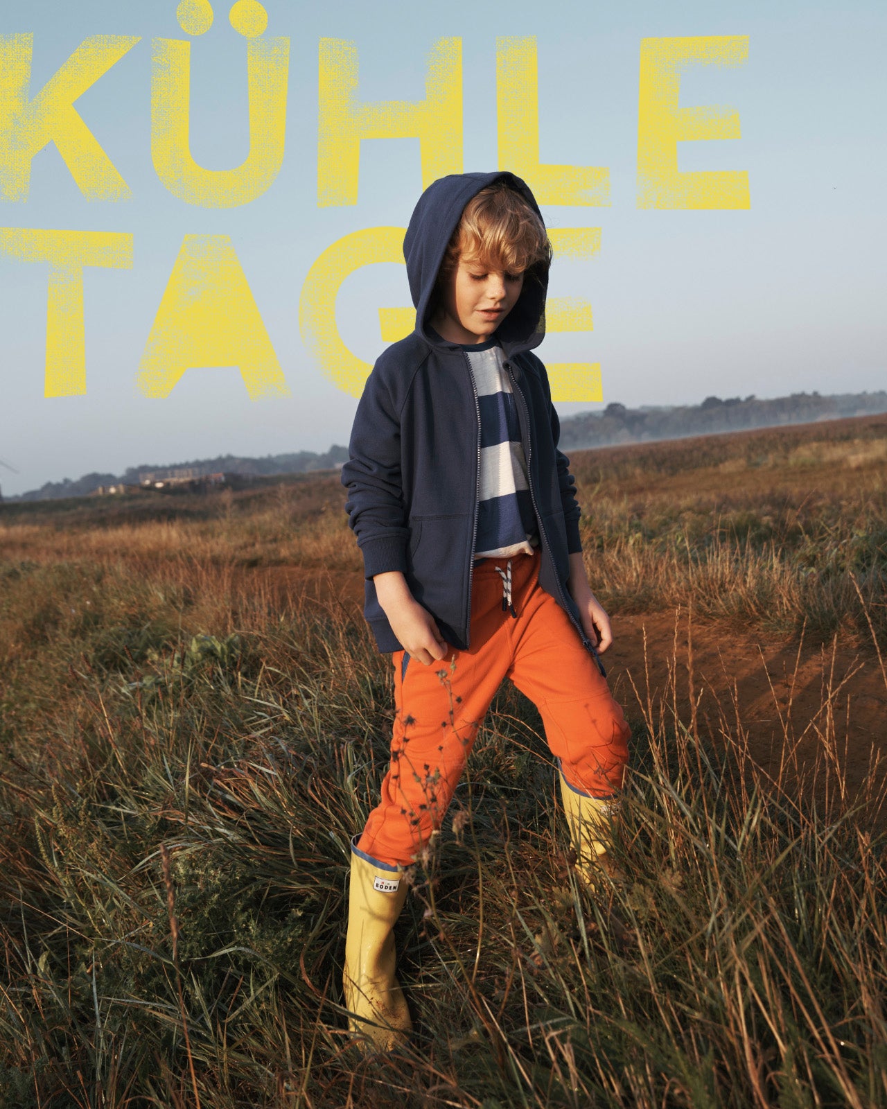 Kuhle Tage: Boy in a field wearing a Boden hoodie