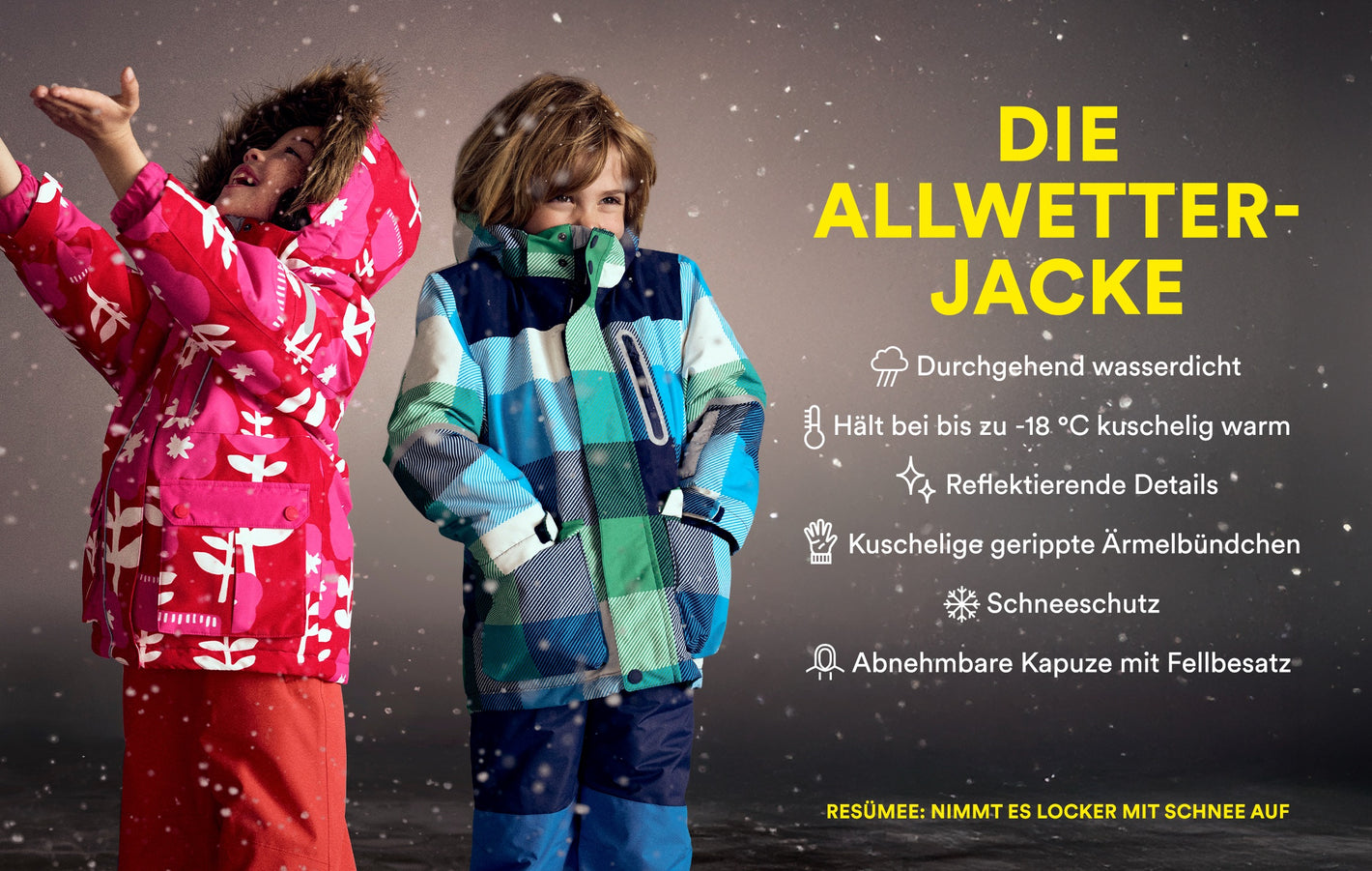 Zwei Kinder in Schneekleidung von Boden stehen im Schnee und lächeln.