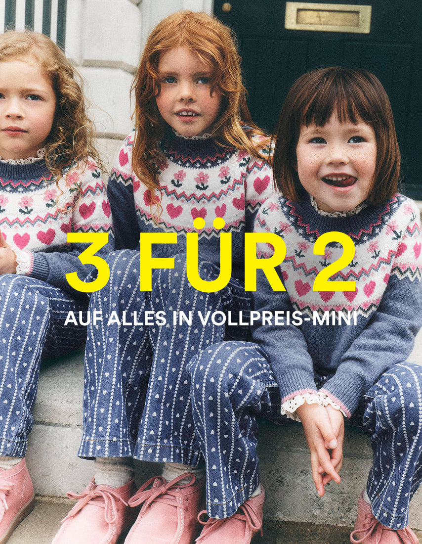 Drei junge Mädchen sitzen auf einer Steintreppe und tragen passende Strickpullover und Hosen mit einem Herz- und Sternmuster. In der Mitte steht in großen gelben Buchstaben „3 FOR 2“, darunter in kleinerer weißer Schrift „ON ALL FULL PRICE MINI“.