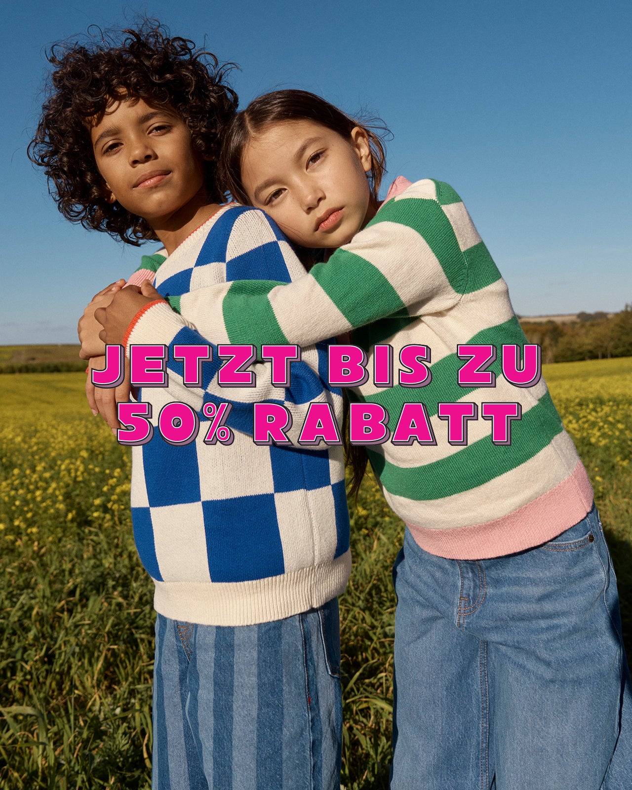 Zwei Kinder, die sich auf einer Wiese umarmen, mit einem darüberliegenden Werbetext