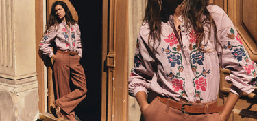 Ein Model trägt ein hellrosa Langarmhemd mit Knöpfen, das auf der Vorderseite und an den Ärmeln mit bunten Blumenstickereien verziert ist, dazu eine braune Hose mit weitem Bein und einen braunen Gürtel. Das Modell wird in einer Lifestyle-Aufnahme im Split-Screen-Format vor einem in warmen Farbtönen gehaltenen Türrahmen aus Stein und Holz gezeigt.
