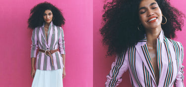 Frau in gestreiftem Blazer und Rock vor rosa Hintergrund