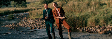Zwei Personen stehen an einem Fluss mit malerischer Kulisse