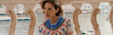 Woman wearing colourful Boden knit, sat on a balcony
